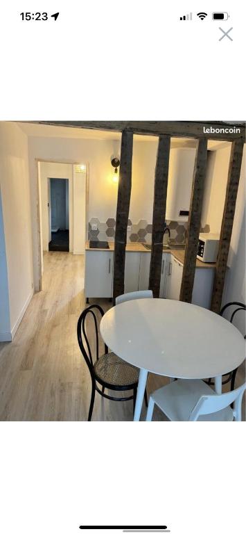 a room with two tables and chairs in a room at Appartement centre ville in LʼAigle