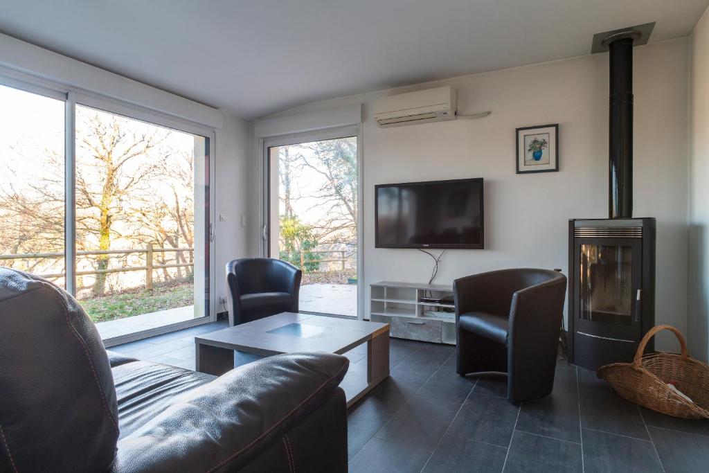 salon z kanapą i kominkiem w obiekcie Le Fusain - Maison climatisée pour 6 w mieście Pont-Aven