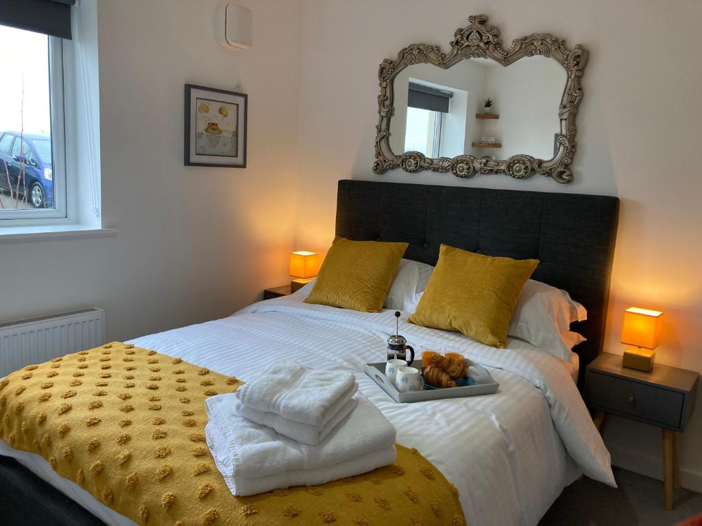 a bedroom with a large bed with a mirror on the wall at Dog Friendly Stylish Modern Flat, near Beach in Newquay