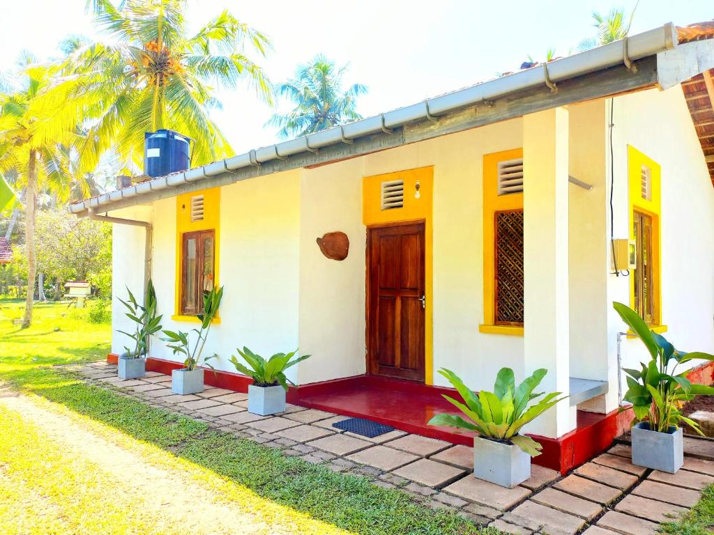 una casa con fachada amarilla y roja en Coco Garden Villas, en Hikkaduwa