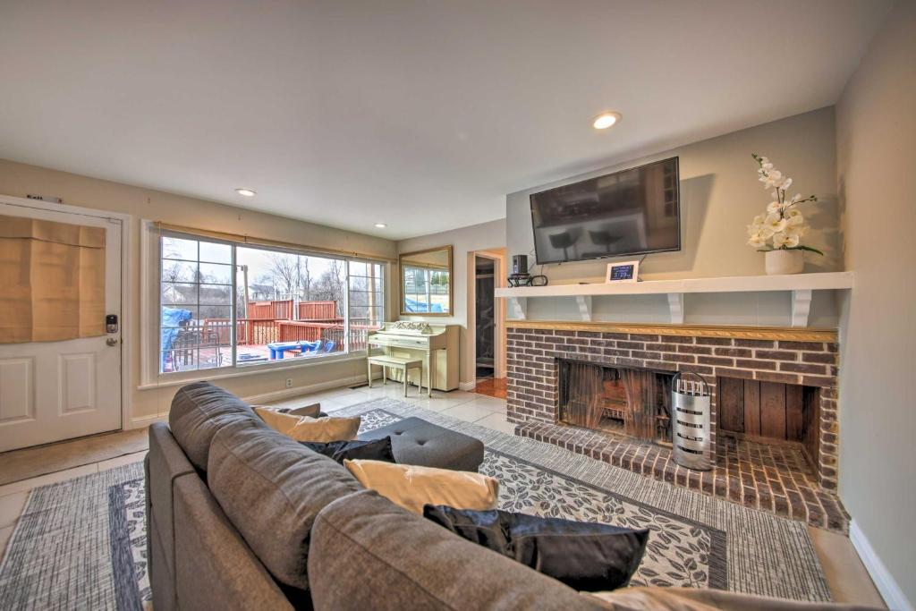 a living room with a couch and a fireplace at Hidden Paradise on 5 Acres with Hot Tub and Deck! 
