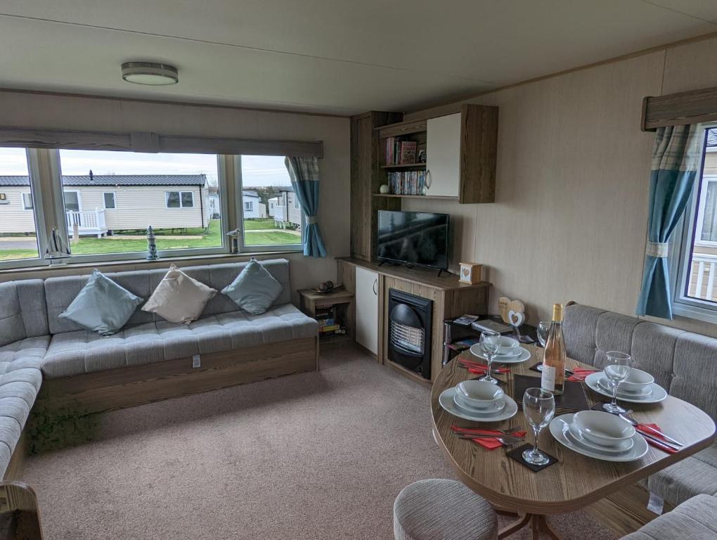 a living room with a couch and a table at Haven Holiday Home Littlesea Sleeps 6 in Weymouth