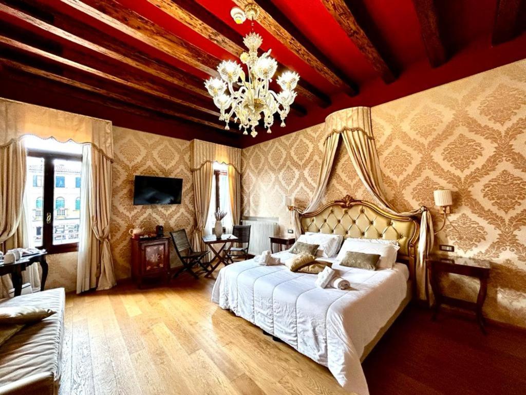 una camera con un grande letto e un lampadario a braccio di Dream suites a Venezia