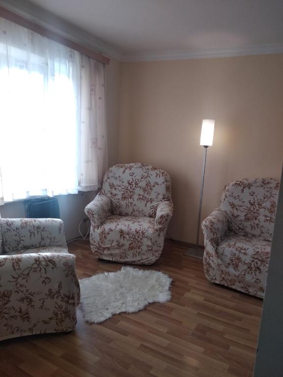 sala de estar con 2 sillas y alfombra en уют en Rustavi