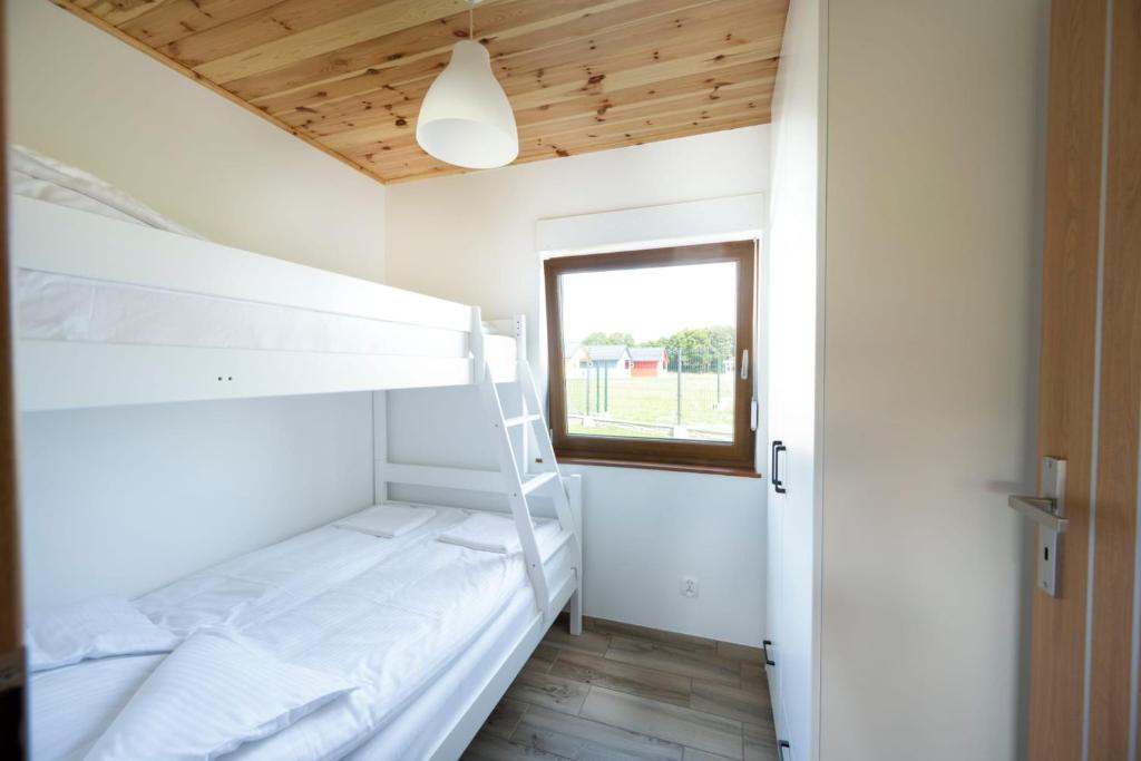 a bedroom with two bunk beds and a window at Kwiat Paproci in Gąski