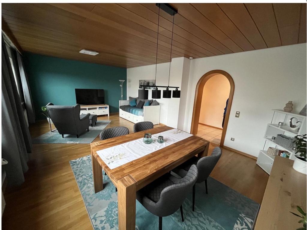 sala de estar con mesa de madera y sillas en Ferienwohnung Kessler, en Ommersheim