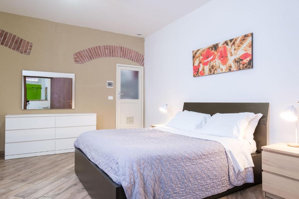 ein Schlafzimmer mit einem Bett, einer Kommode und einem TV in der Unterkunft House Under the Tower by Studio Vita in Bologna