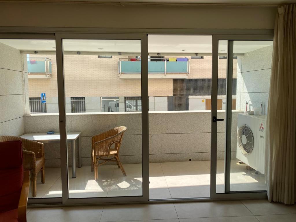 a room with sliding glass doors and a table and a washing machine at Belmar in Les Cases d'Alcanar