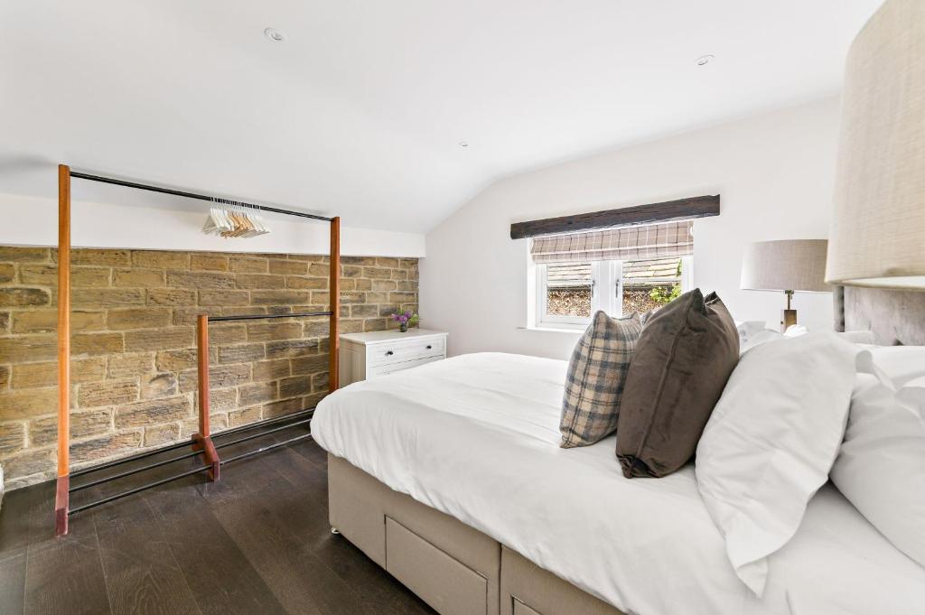 1 dormitorio con 1 cama grande y pared de ladrillo en Chantry House en Barnsley