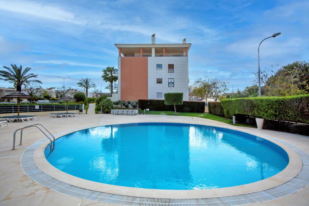 a swimming pool in front of a building at Luxury Apartment with Pool in Albufeira