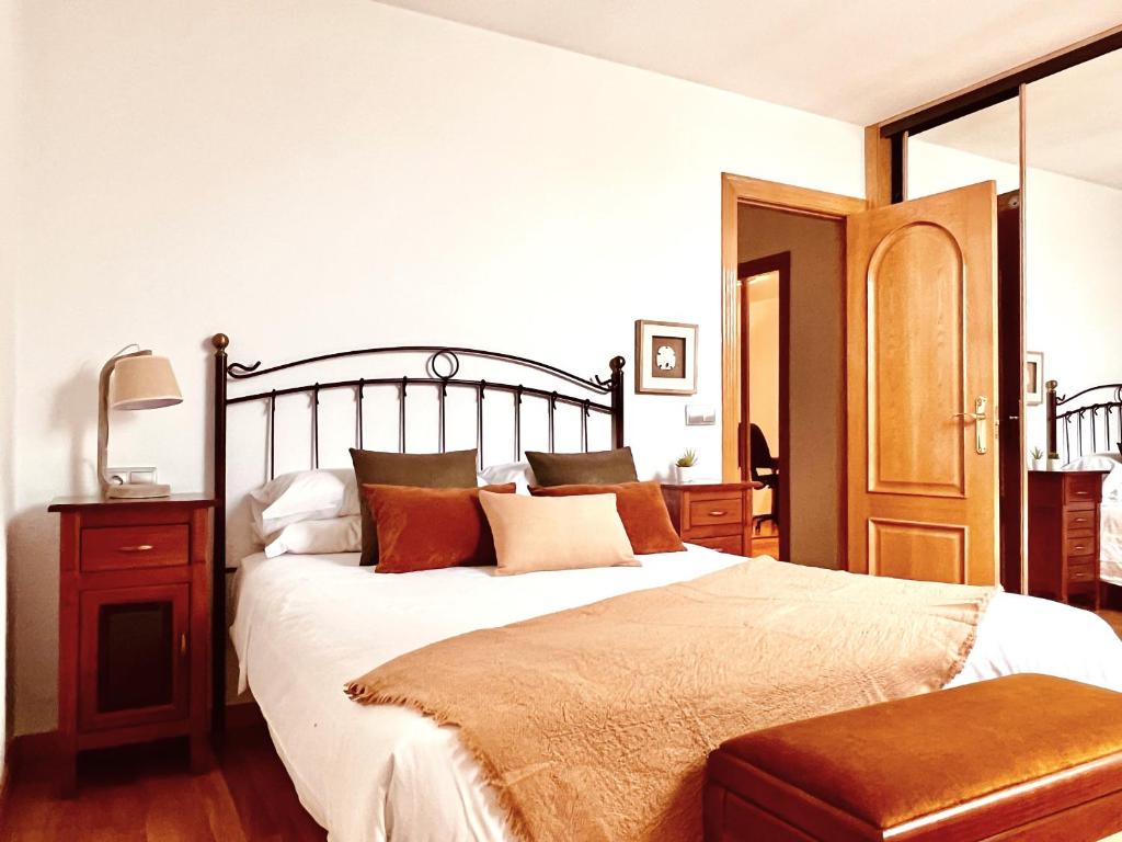 ein Schlafzimmer mit einem großen Bett mit weißer Bettwäsche und Kissen in der Unterkunft Housingleón - Conde Duplex con garaje gratuito in León