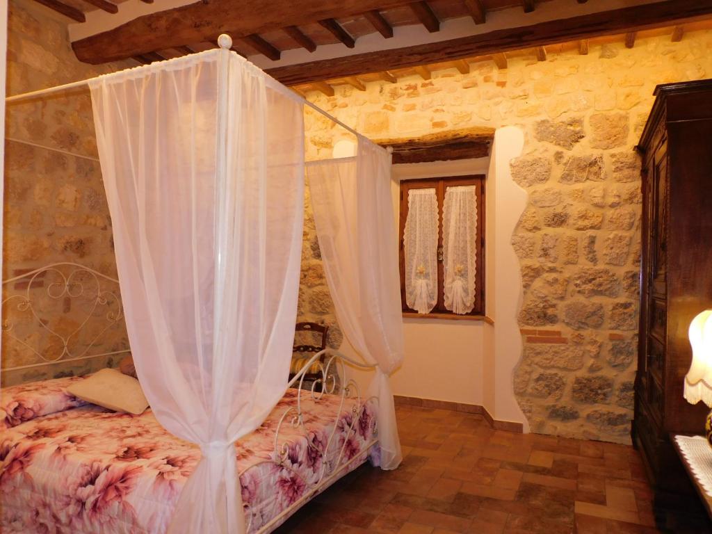 a bedroom with a bed with a mosquito net at Sognare nel Castello in Monteriggioni