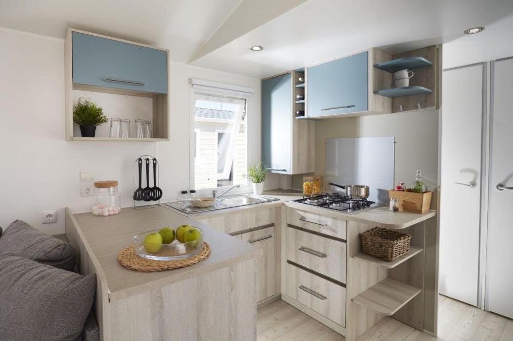 a kitchen with a counter with a bowl of fruit on it at Grand mobil home tout confort ES 93 in Fréjus