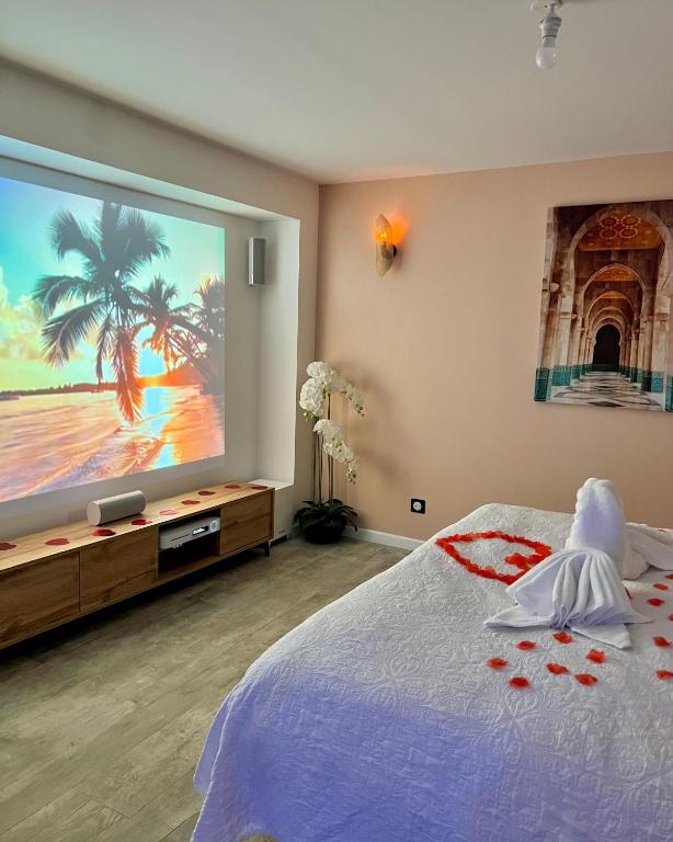 a bedroom with a large projection screen of a beach at BIOTY CHILL &amp; SPA in Le Blanc-Mesnil