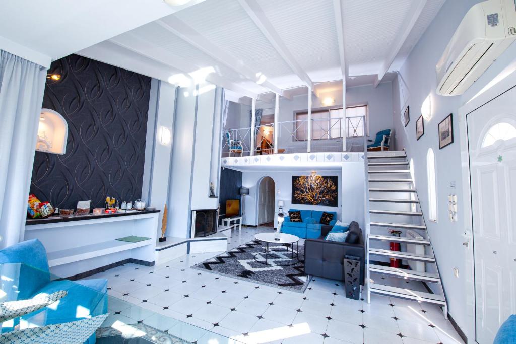 ein Wohnzimmer mit einer Treppe und ein Wohnzimmer mit blauen Möbeln in der Unterkunft Natalie Apartments in Artemida