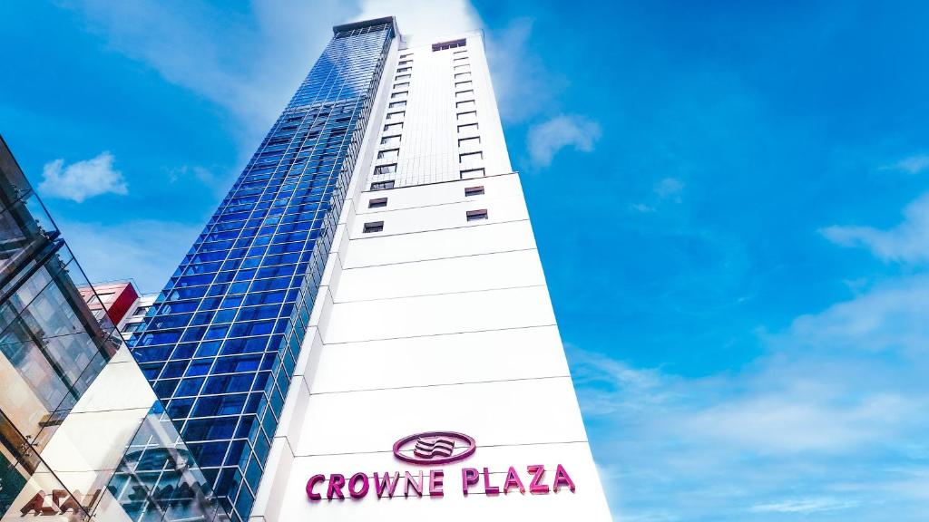 um edifício branco alto com um cartaz em Crowne Plaza Auckland, an IHG Hotel em Auckland