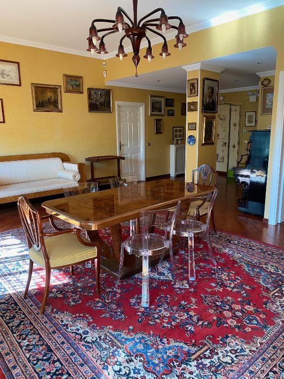 salon ze stołem i krzesłami na dywanie w obiekcie MAGGIE HOUSE w Rzymie