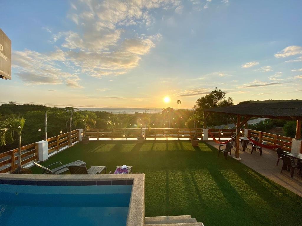 uitzicht op een zwembad op een huis met zonsondergang bij Hotel Ummagumma in Montañita
