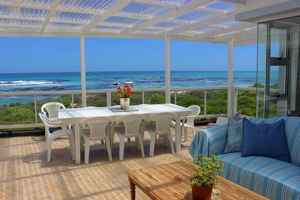 a living room with a table and a couch and the ocean at Paradise@Pearly in Pearly Beach