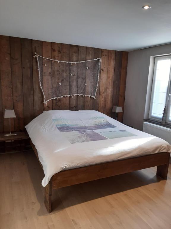 um quarto com uma cama e uma cabeceira em madeira em Het Helmgras em Middelkerke