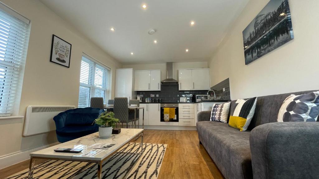 a living room with a couch and a table at Stylish 1 bedroom flat with free parking in Woking