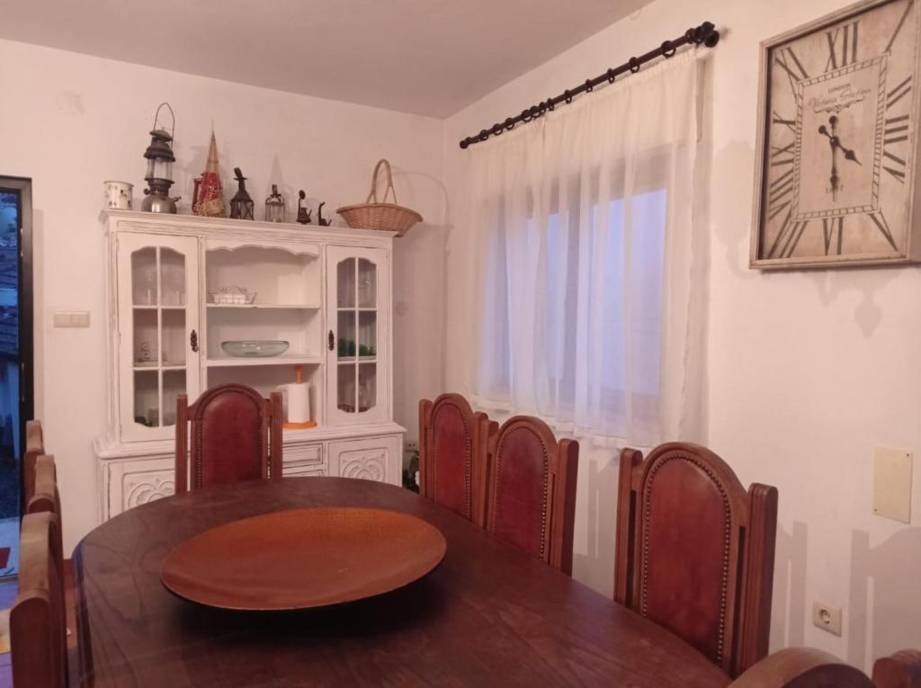 jadalnia ze stołem, krzesłami i zegarem w obiekcie Gerês e Cabreira - Casa Alexandrina Vilar w mieście Frades