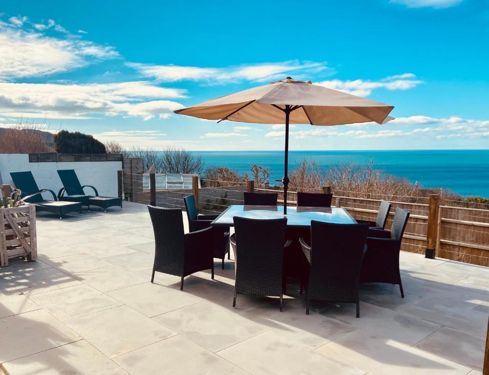 a patio with an umbrella and a table and chairs at Chesil View in Castletown
