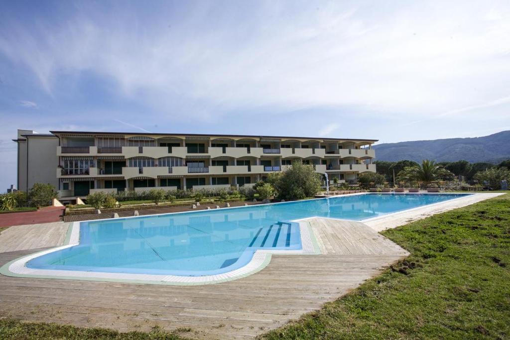 a large swimming pool in front of a building at Appartamenti Verde Blu in Capoliveri