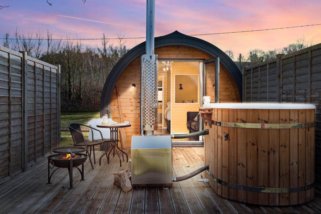 a gazebo with a hot tub and a table at Morgan Sweet, Apple Tree Glamping, Nr Wells in Wells