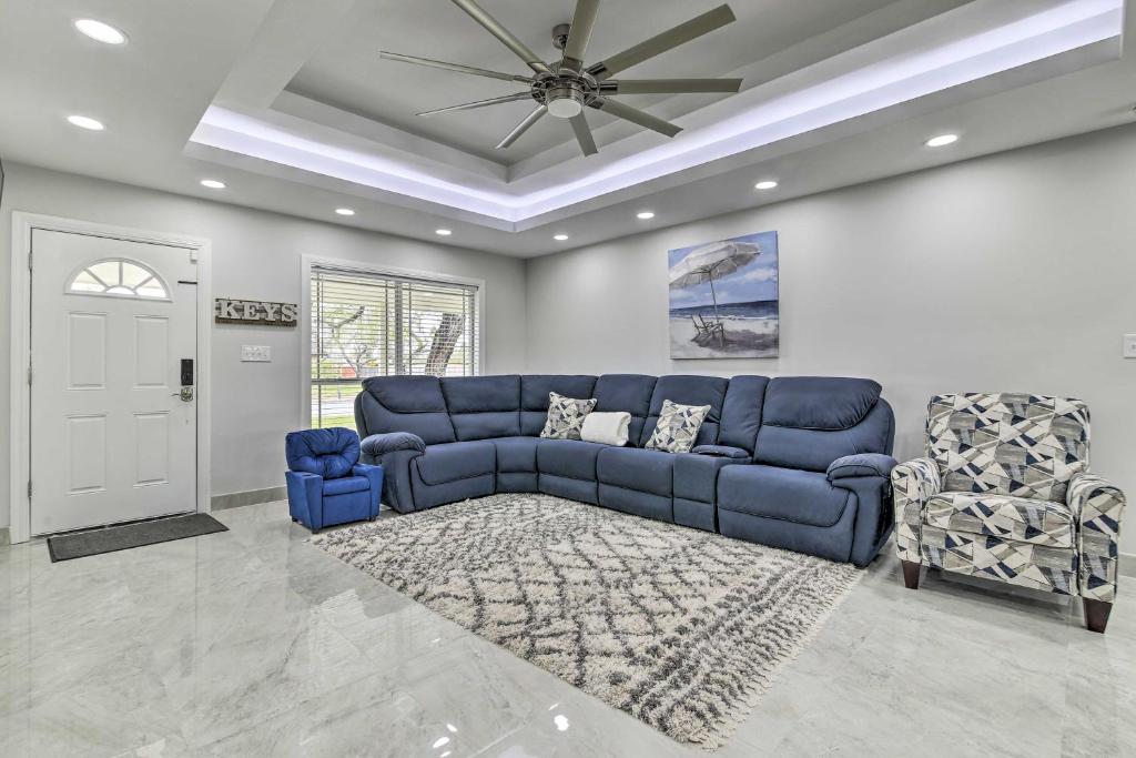 a living room with a blue couch and two chairs at Spacious Texas Vacation Home Near Gulf Coast in Brownsville