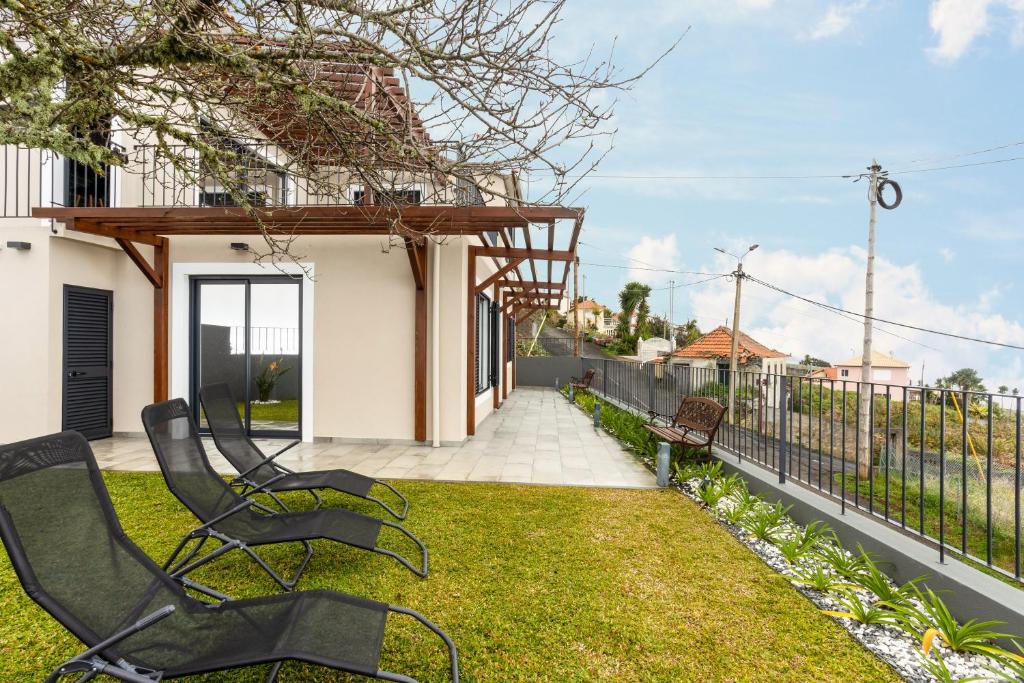 un gruppo di sedie seduti sull'erba vicino a una recinzione di Referta Apartamento T2 a Prazeres