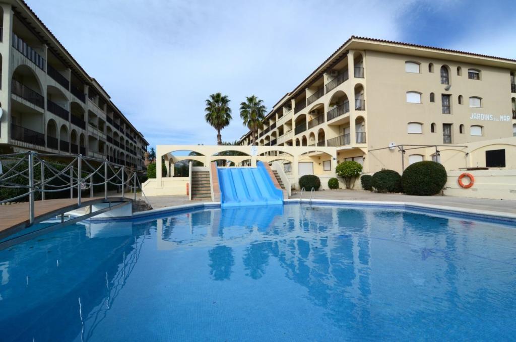 una gran piscina con un tobogán frente a un edificio en Jardins del mar 83-D, en L'Estartit