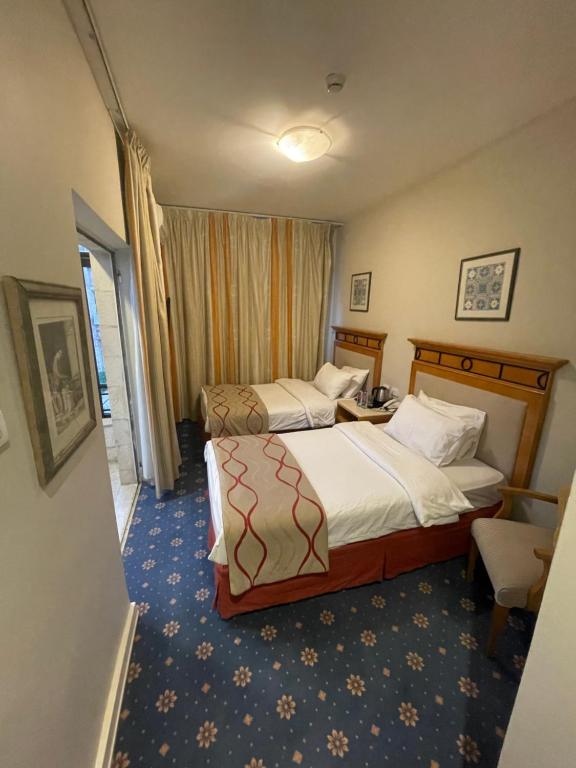 a hotel room with two beds and a window at The Y Hotel in Amman