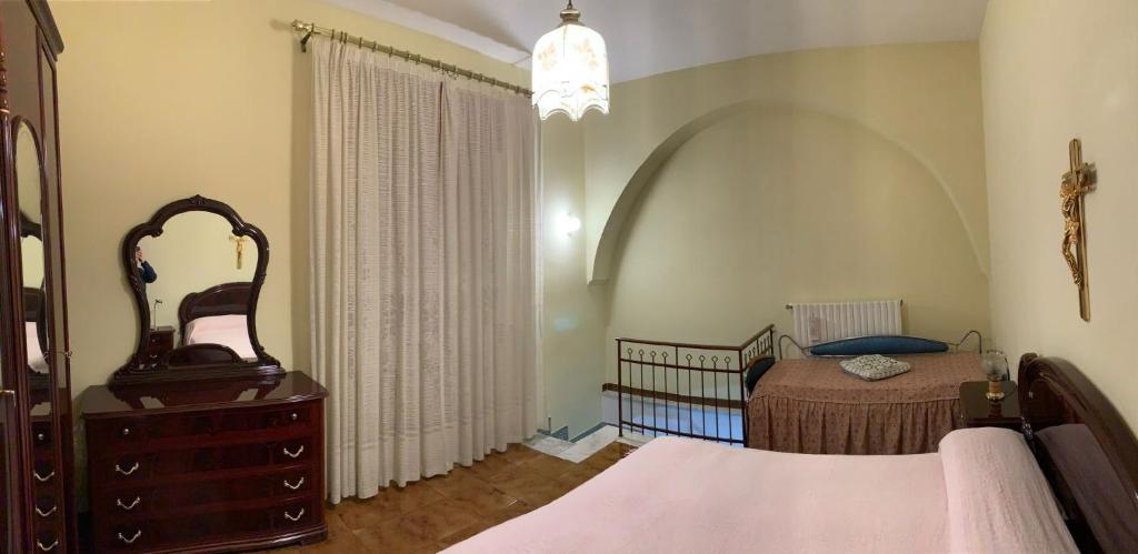 sypialnia z łóżkiem, komodą i lustrem w obiekcie Casa vacanze Umberto I w mieście Ascoli Satriano