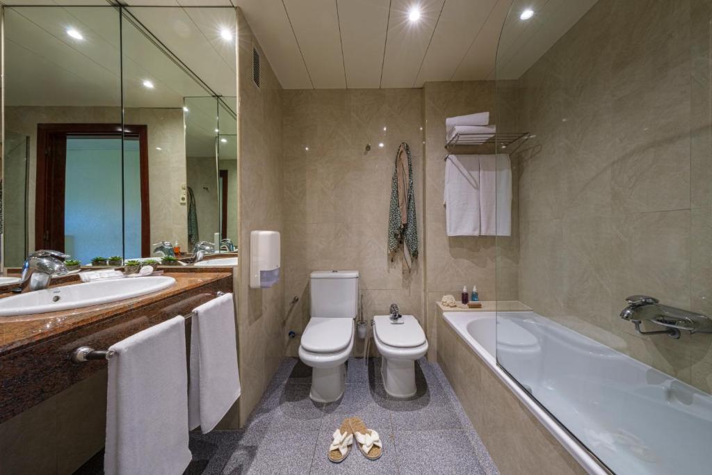a bathroom with a tub and a toilet and a sink at Estival Park Silmar in La Pineda