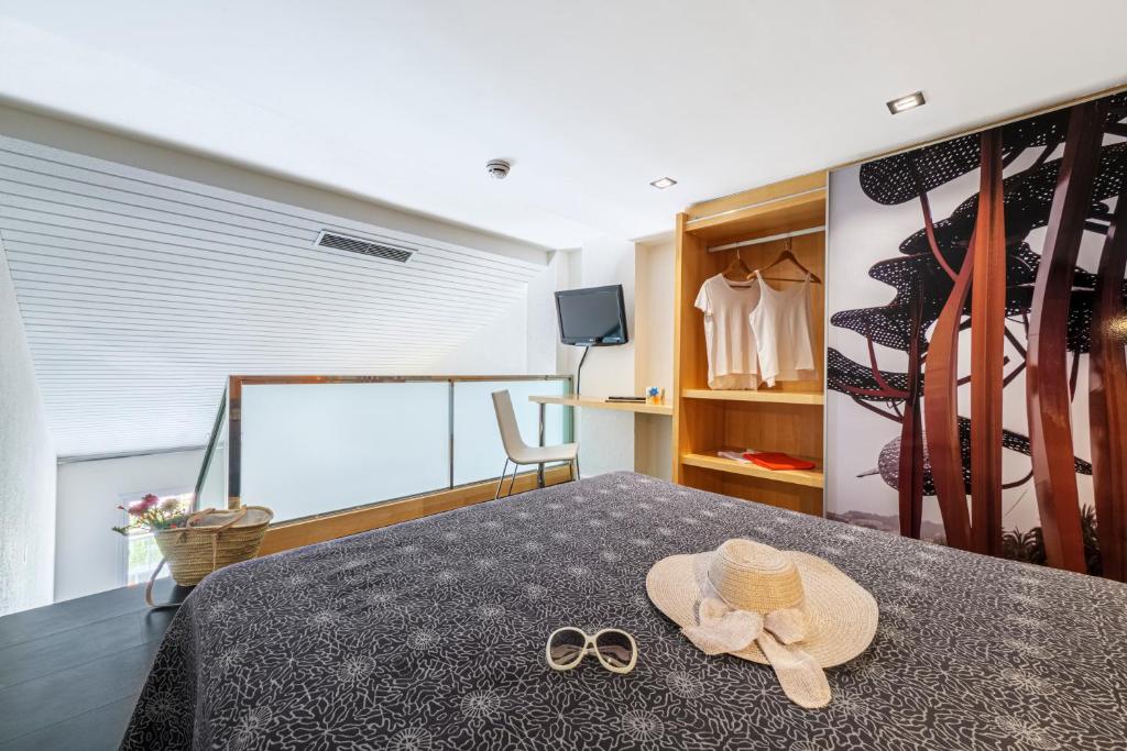 a bedroom with a bed with a hat and pair of glasses at Estival Park Silmar in La Pineda