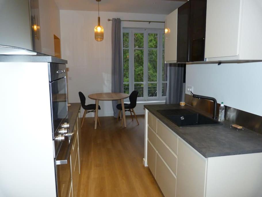 eine Küche mit einem Tisch und einer Arbeitsplatte in der Unterkunft Le soleil du Revard in Aix-les-Bains