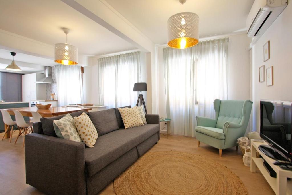 a living room with a couch and a dining room at Apartamento SofiSara in Tavira