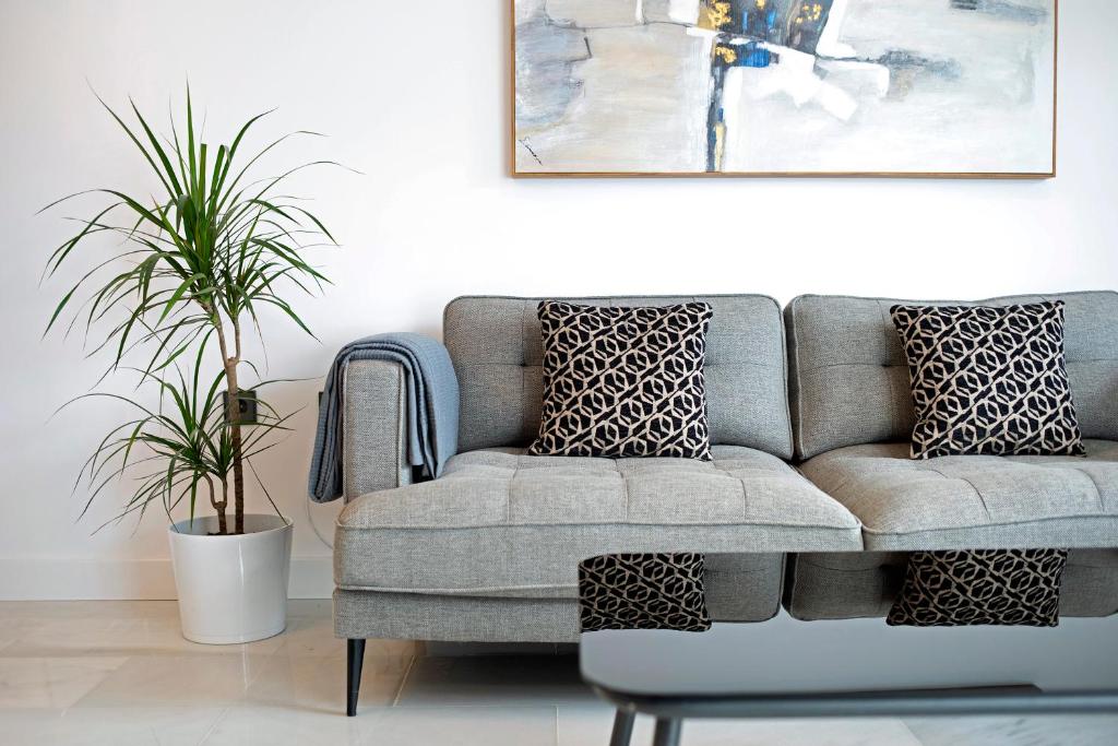 a living room with a couch and two plants at MARIA DEL MAR SEA APARTMENT in Chiclana de la Frontera