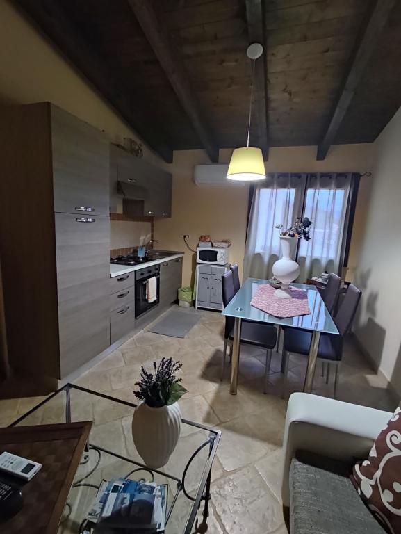 ein Wohnzimmer mit einem Tisch und einer Küche in der Unterkunft Alex's Apartment in Iglesias