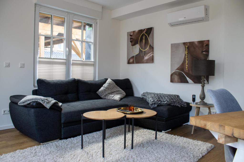 a living room with a blue couch and a table at Pension Wagener in Wachtendonk