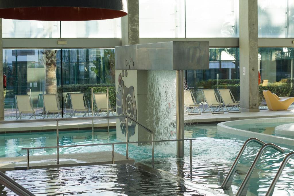 a swimming pool with a fountain in a building at Estival Park Silmar in La Pineda