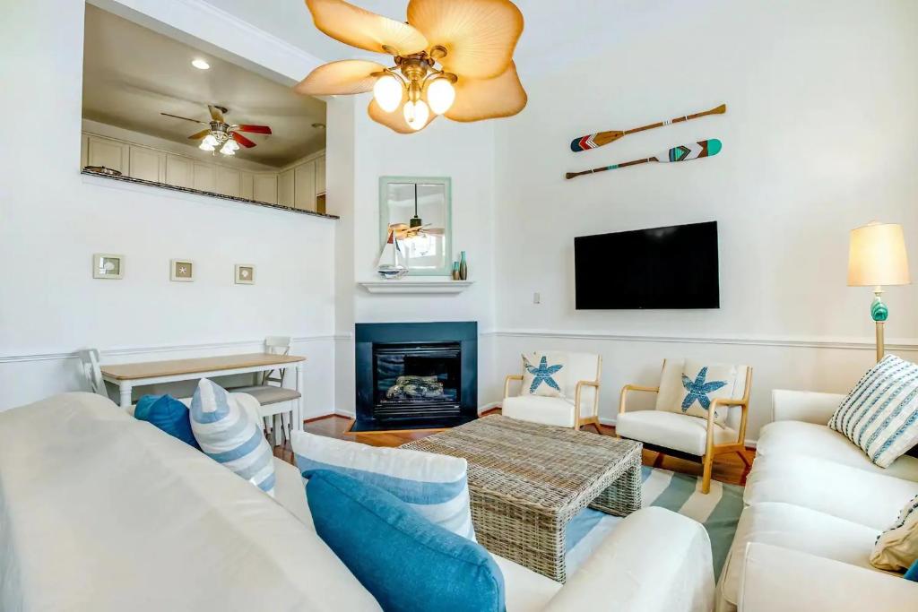 a living room with white furniture and a fireplace at Relaxing Bethany Beach Retreat, Pools, Families Welcome Including Dogs! in Ocean View