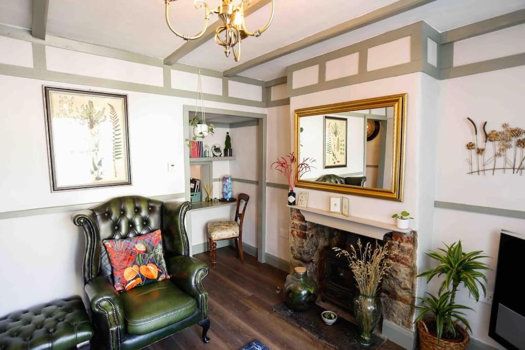 a living room with a fireplace and a green leather chair at *Stunning* The Botanist Rest Ventnor IOW in Ventnor