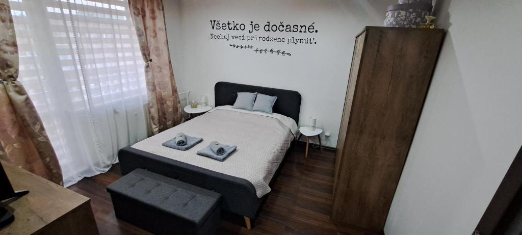 a bedroom with a bed and a sign on the wall at Apartmán Zemplín in Michalovce