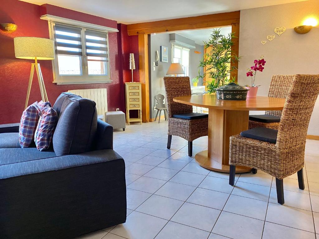 a living room with a blue couch and a table at Gite Géranium*** in Eguisheim