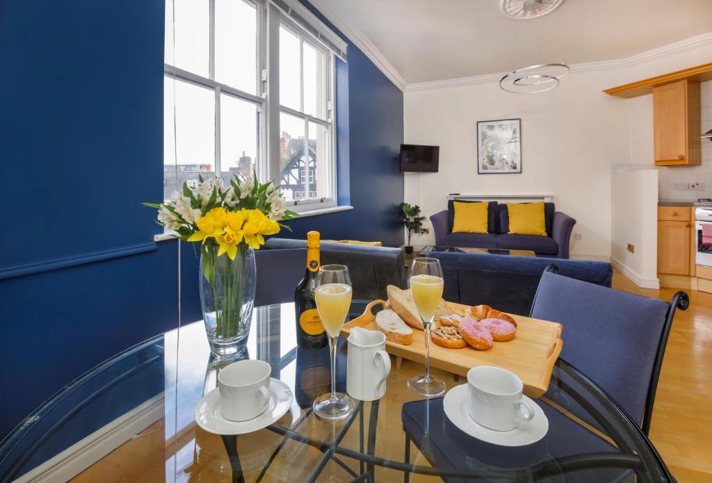 uma sala de jantar com uma mesa de vidro e uma parede azul em William Morris on the historic Shambles York em York