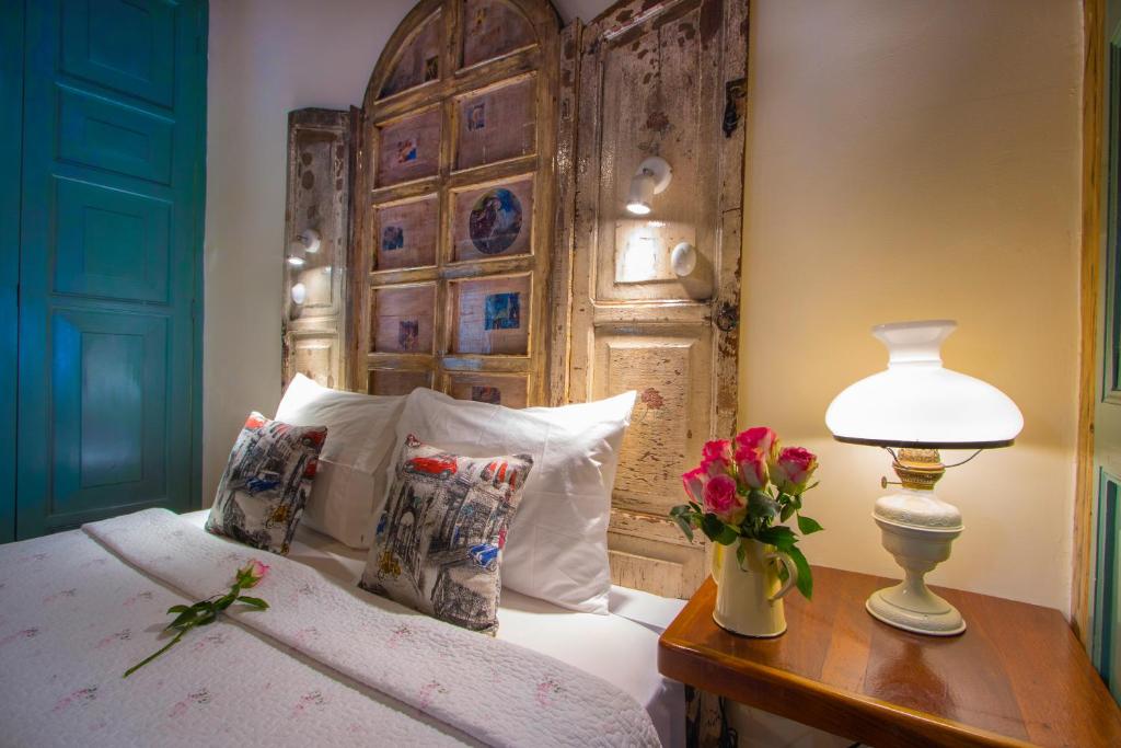 a bedroom with a bed with a wooden headboard at Old Town Quito Suites, Heritage Boutique Hotel, Where Every Detail Tells a Story in Quito