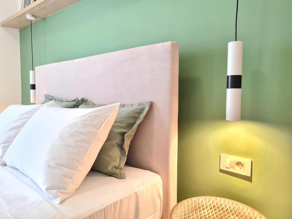 1 cama con almohada blanca y pared verde en Anna & Zampia central apts, en Kissamos