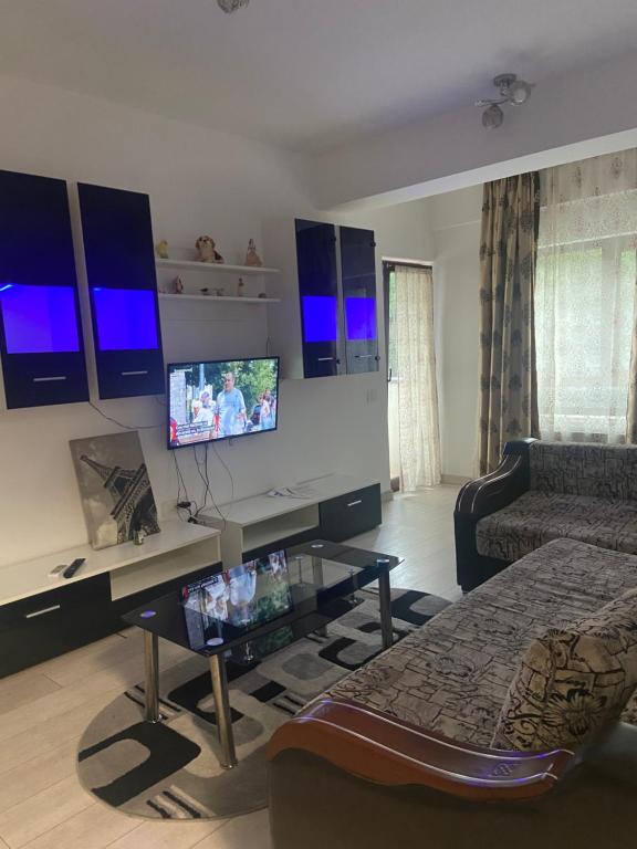 a living room with a desk with a tv and a couch at Bridge tower Residence in Iaşi